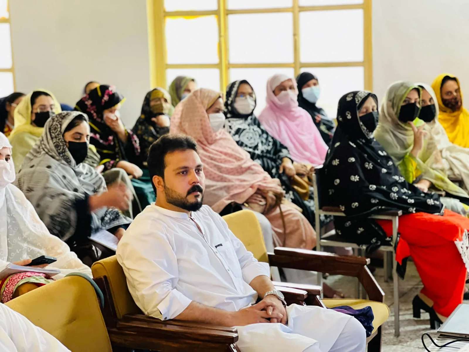 Abdullah Khan seated with seminar attendees in the college classroom.