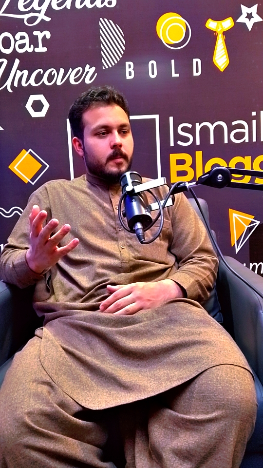 Abdullah Khan speaking into a microphone during a podcast recording