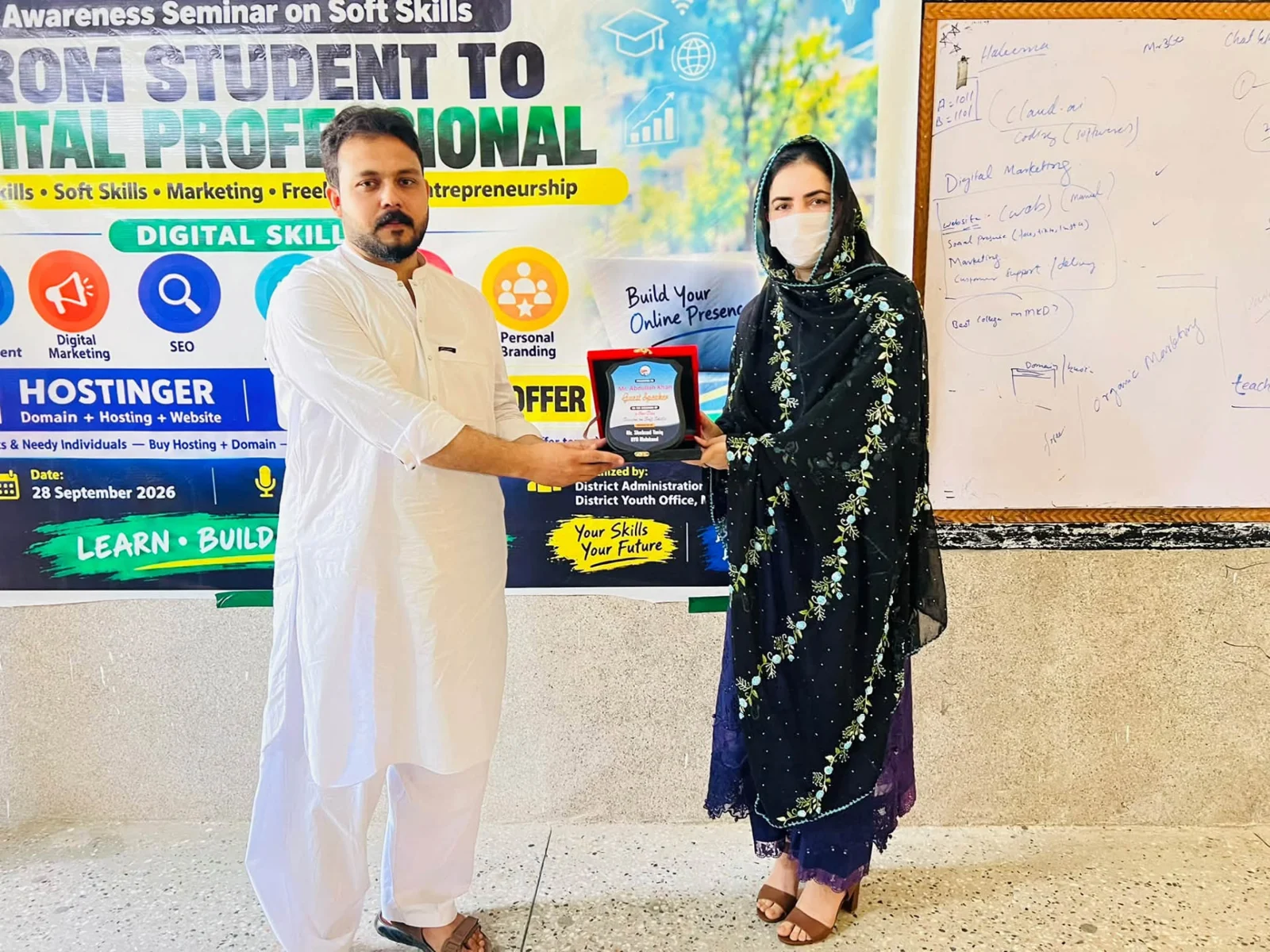 Abdullah Khan receiving a commemorative award from Ms. Shaista Khatak, Assistant Commissioner, at the seminar.